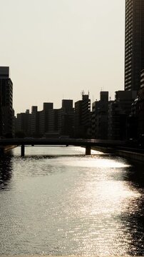夕暮れ時の太陽に照らされてキラキラ輝く道頓堀川の水面のスローモーション