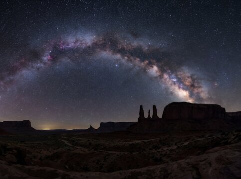Vast Milky Way Galaxy Arches Over Desert Rock Formations Under Starry Night Sky.