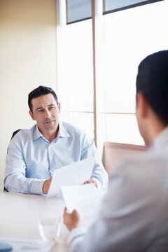 HR, man and interview with paperwork in office for hiring process, employee screening or vacancy. Serious, candidate and manager with CV for talent acquisition, headhunter and recruitment checklist