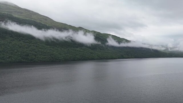 Aerial scenery of Loch Lomond with mist over the hills and still freshwater in the Scottish Highlands national park.