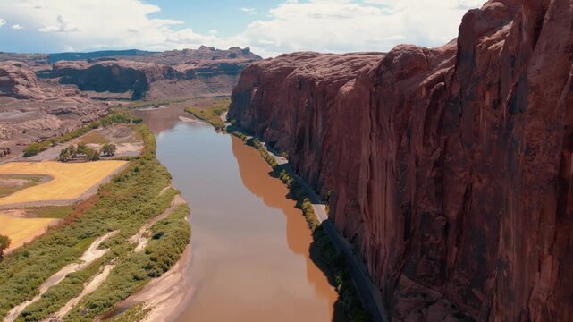 Wall Street near Moab, Utah from a drone aerial view showing red rock cliffs and Colorado River below.