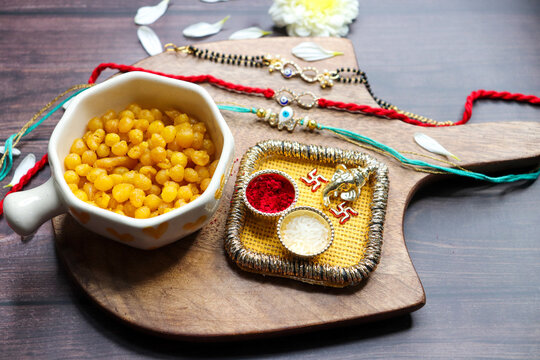 Indian festival Raksha bandhan. Rakhi thali with diya, flowers and tilak with sweet boondi or bundi. Puja thali for rakhi festival with roli chawal. copy space. also known as Narali Purnima. 