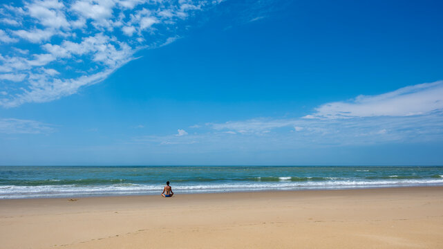 Femme assise en position de yoga face &agrave; l'oc&eacute;an atlantique sur la plage de la pointe Espagnole dans le d&eacute;partement de Charente Maritime