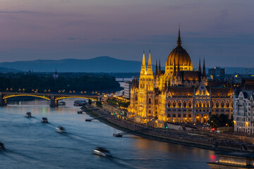 Obraz premium hungarian parliament building illuminated over danube river at dusk