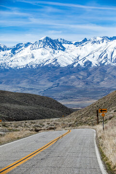 Empty two-lane highway through desert to mountains