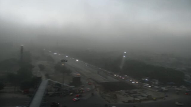 Heavy rain storm over city skyline. Dark monsoon clouds covering urban Delhi NCR roads.