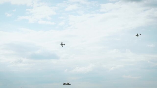 A white smoke loop pattern created by an aerobatic airplane in a clear blue sky with soft white clouds.