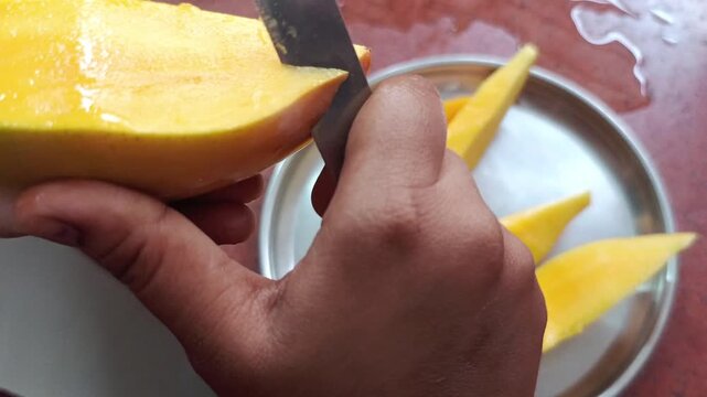 Slicing Fresh Ripe Mango with Knife on Plate - Woman Hands Cutting Mango