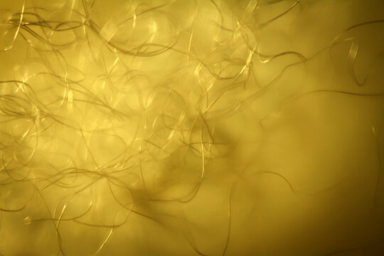 Extreme macro of polyester stable fiber on yellow background. Selective focus, shallow depth of field. Abstract dreamy background