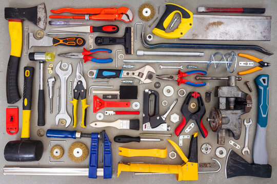 Flat lay of old and new hand tools on concrete background. Large collection of various tools and bits arranged on concrete.