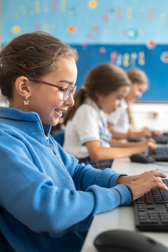Girls using desktop computer in school computer lab