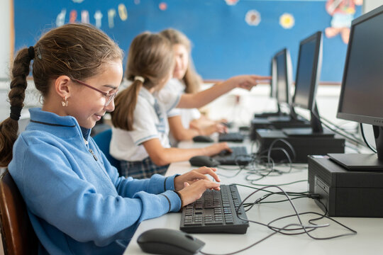 Girls using desktop computer in school computer lab