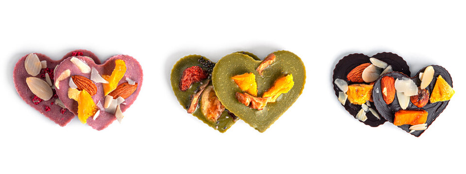 Raw heart shaped chocolate with dried fruits and nuts on a white background. High quality photo