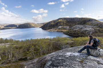 Fototapeta premium Woman hiking on mountain Oretoppen ( norwegian Øretoppen ) on South Varanger, in Finnmark County, Norway