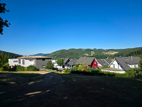 germany, modern sonnensiedlung neighborhood in elzach surrounded by breathtaking black forest scenery beneath vibrant deep blue summer sky