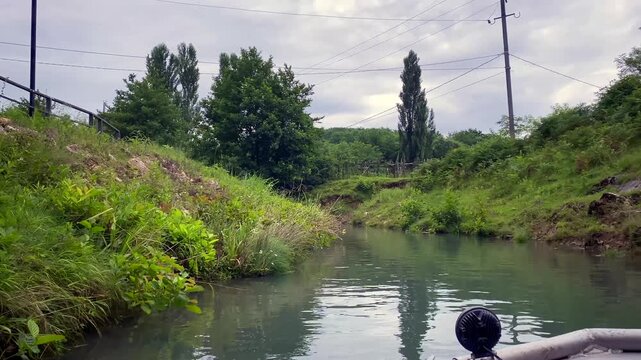 Tourists exiting Prometheus Cave by boat enter an outdoor canal in Georgia, completing a guided underground attraction route for destination marketing, regional tourism campaigns