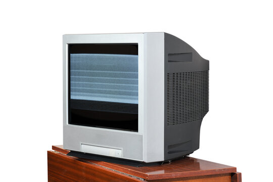 An old television with static on the screen sits on a vintage 1990s/1980s nightstand against a white background.