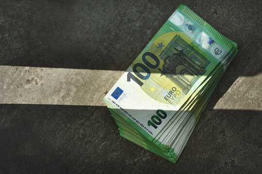 100 euro banknotes in dramatic light.