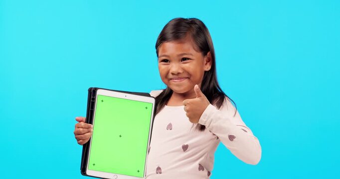 Happy little girl, thumbs up and tablet mockup for social media against a blue studio background. Portrait of female child or kid smile with like emoji, yes sign or approval for technology success