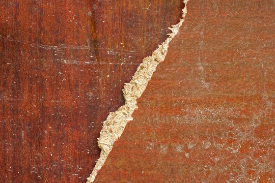 two old broken brown dirty pieces of plywood chipboard on the street
