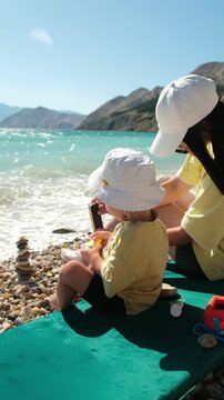 Adult and toddler playing by bright blue water