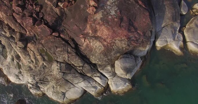 Drone footage of rocky shore and blue green water at Goa