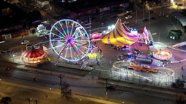 Nighttime amusement park rides, such as Ferris wheels, circus tent, and Ferris wheel, in the Maipu commune, Metropolitan Region, Chile