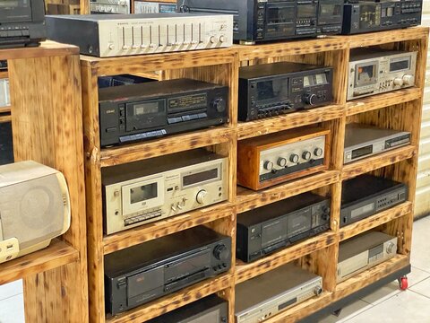 Jakarta, Indonesia - July 17, 2026: Vintage audio cassette decks and stereo amplifiers displayed on a wooden shelf at a retro shop in Blok M.