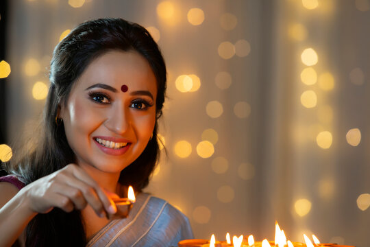 Woman smiling with a diya in her hand