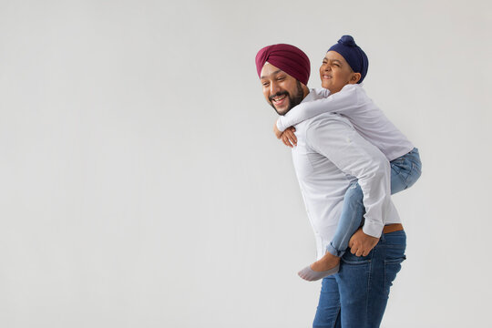 A SIKH FATHER SON LAUGHING AND PLAYING TOGETHER