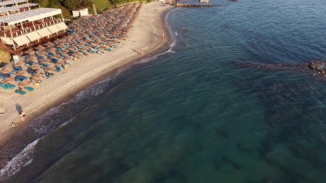 Overhead aerial view of a secluded beach, submerged rocks and forested coastline at Kepi i Rodonit, Albania.