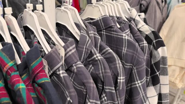 Brightly colored flannel shirts hang neatly on racks in a lively market. Shoppers browse and enjoy the vibrant atmosphere of the autumn season. A perfect day for fashion exploration.