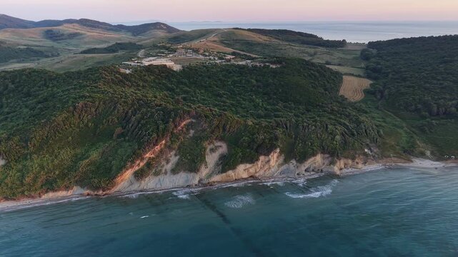 Wide drone view of a quiet beach, forested hills and clear Adriatic Sea along the coast of Kepi i Rodonit, Albania.
