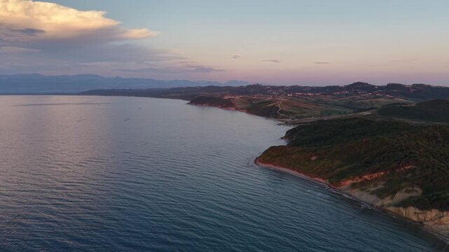 Wide drone view of a quiet beach, forested hills and clear Adriatic Sea along the coast of Kepi i Rodonit, Albania.
