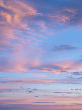 Pale pink clouds against blue sky