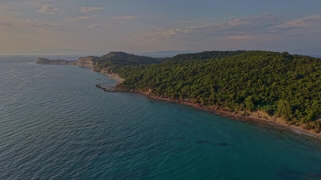 Wide drone view of a quiet beach, forested hills and clear Adriatic Sea along the coast of Kepi i Rodonit, Albania.
