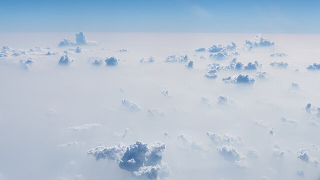 Over the clouds high in the sky by plane