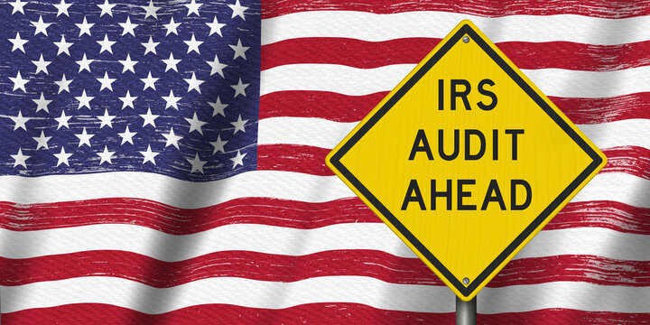 IRS Audit Ahead yellow warning sign on the American flag tax review
