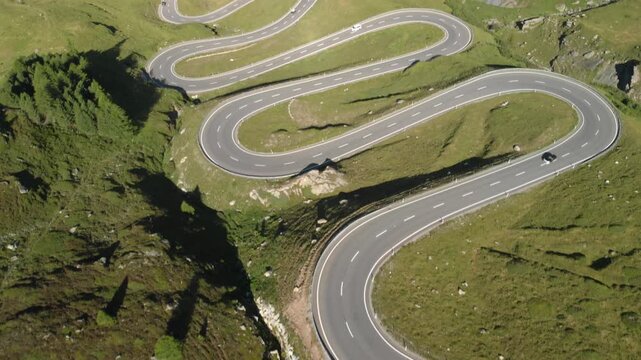 Winding mountain road in the Alps with cars driving, Albula Pass, Switzerland 