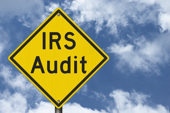IRS Audit yellow warning sign with sky tax review