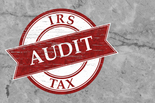 Red distressed IRS Tax Audit stamp on weathered gray for financial review