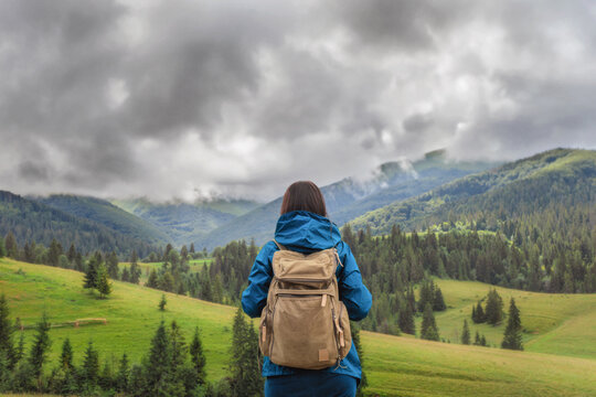Female hiker with backpack looking at mountains