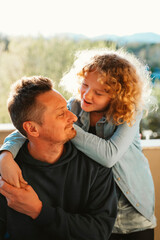 Fototapeta premium Teenage daughter shares important news with her father while he listens attentively and engages in conversation. The image highlights trust, open communication, emotional support and the strong bond b