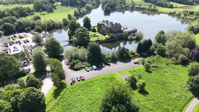 Aerial drone view of castle estate on Loch Faskally in Pitlochry, surrounded by woodland, landscaped grounds, and calm water, showcasing the scenic countryside of Perthshire.