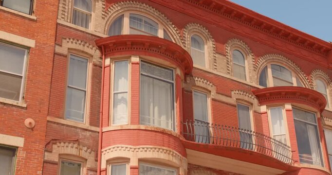 Perspective looking up shot of the traditional and ornate red brick historic building facade featuring arched windows of Galena architecture, Galena, Illinois, USA