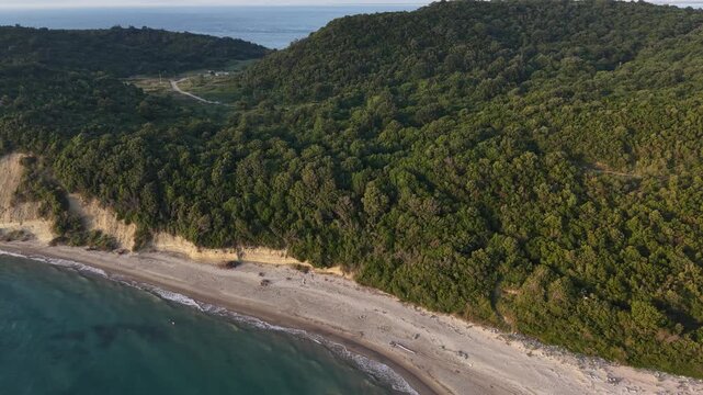 Wide drone view of a quiet beach, forested hills and clear Adriatic Sea along the coast of Kepi i Rodonit, Albania.
