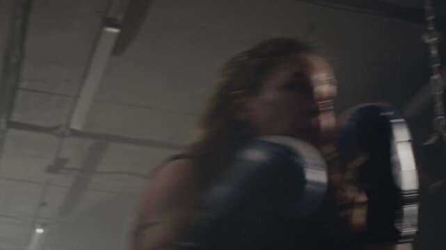 Caucasian young woman practicing boxing combinations with trainer. Footage ideal for fitness brand commercials, gym advertisements, and female empowerment campaigns