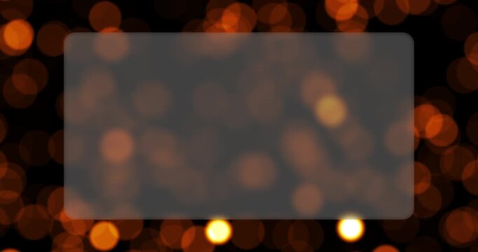 A frosted glass rectangle sits centered in a dynamic field of glowing bokeh particles. Continuous looping movement gives this golden abstract background a luxurious look.