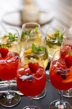 Glasses with white and red cocktails and fresh strawberry during festive aperitivo