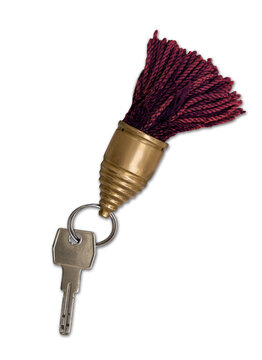 Old hotel key with decorative tassel key fob on elegant vintage background